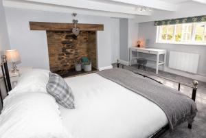 a bedroom with a large white bed and a desk at The Old Farmhouse in Liskeard