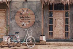 una bicicletta parcheggiata di fronte a un edificio con un cartello di Villa Palma Gili Meno - Private Pool a Gili Meno