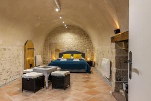 ein Schlafzimmer mit einem Bett in einem Steinzimmer in der Unterkunft Le Troglogite Mignon - Maison et Jardin in Amboise