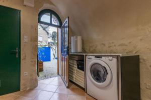 eine Waschmaschine in einem Zimmer mit Tür in der Unterkunft Le Troglogite Mignon - Maison et Jardin in Amboise