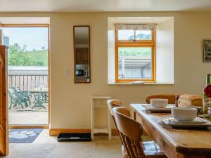 d'une salle à manger avec une table, des chaises et une fenêtre. dans l'établissement 2 Bed in Helmsley TGCHF, à Chop Gate