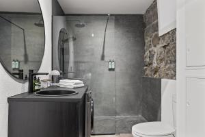 uma casa de banho com um lavatório, um chuveiro e um WC. em Historic Villa in downtown Reykjavik em Reykjavík