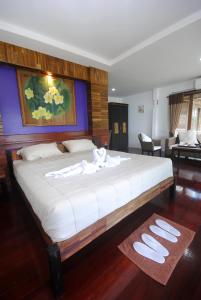 a bedroom with a large bed with white sheets at New Ozone Resort & Spa in Ko Lanta
