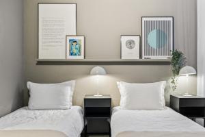 雷克雅維克的住宿－Historic Villa in downtown Reykjavik，一间卧室配有两张带白色床单和两盏灯的床。