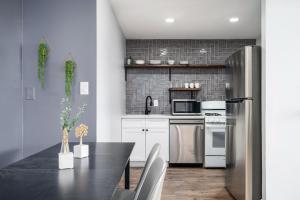 a kitchen with a table and a stainless steel refrigerator at Atlanta Downtown City View Free Onsite Parking Entire Condo LM1607 in Atlanta