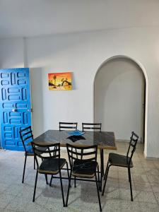 a dining room table with chairs and a painting on the wall at App 2 chambres rdc 200m de la plage in Mezraya