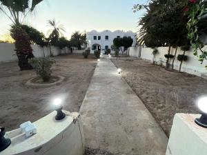 a pathway leading to a house with lights on it at App 2 chambres rdc 200m de la plage in Mezraya