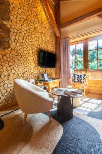 a living room with a chair and a table at Megève Bois - Relais & Châteaux in Demi-Quartier