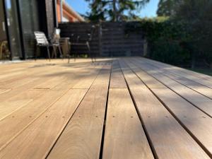 una terraza de madera con una silla en una casa en La Cremaillere en Courseulles-sur-Mer