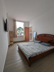 朔莊的住宿－Mai Anh Garden，一间卧室设有一张大床和一个窗户。