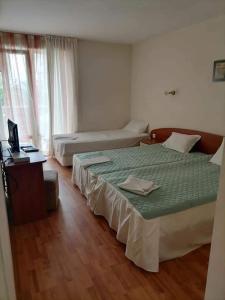 een slaapkamer met 2 bedden en een bureau met een laptop bij Sem.hotel -Afrikana in Sveti Vlas