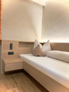 um quarto com uma grande cama branca com almofadas em Aclavaldafur Apart em Nauders