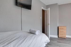 a bedroom with a bed with a television on the wall at LARGE 3 BEDROOM HOME, 3 BATHROOMS, FREE PARKING, FAST WIFI in Belfast