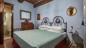 a bedroom with a bed and a bathroom with a mirror at Antico Borgo Frosini in Arezzo