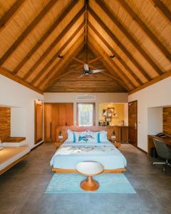 فوشيفارو المالديف في Fushifaru: غرفة نوم كبيرة مع سرير كبير بسقف خشبي