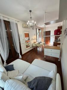 a living room with a white couch and a dining room at Michelangelo Apartment Pescara in Pescara