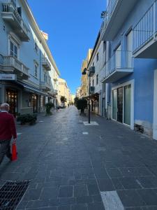a man walking down a cobblestone street next to buildings at Michelangelo Apartment Pescara in Pescara