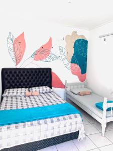 een slaapkamer met een bed en een muurschildering aan de muur bij Pousada Villa Brasil Ocian in Praia Grande