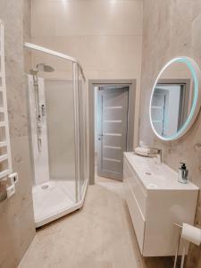 een badkamer met een douche, een wastafel en een spiegel bij CIPRESES in Engure