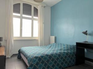 una camera da letto blu con un letto e una finestra di Maison 5 chambres proche toutes commodités a Roubaix Altre 25 foto