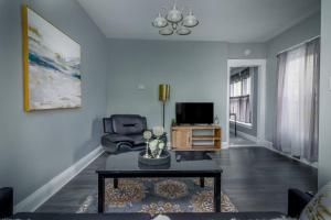 sala de estar con sofá y TV en Cozy 1 bedroom Apartment Sleeps 2-3, en Niagara Falls