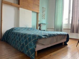 un letto con piumone blu in una camera da letto di Maison 5 chambres proche toutes commodités a Roubaix
