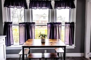 een tafel voor een raam met paarse gordijnen bij Cozy 1 bedroom Apartment Sleeps 2-3 in Niagara Falls