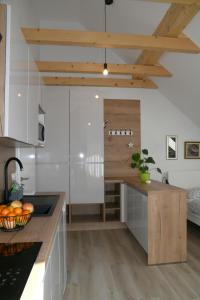 una cucina con mobili bianchi e un piano di lavoro in legno di Apartments Ajda a Bohinj