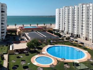 an aerial view of a resort with a swimming pool and the beach at Valdelagrana Mar Ha Apartment in El Puerto de Santa María