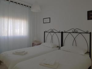 a bedroom with a large white bed with white sheets at Valdelagrana Mar Ha Apartment in El Puerto de Santa María