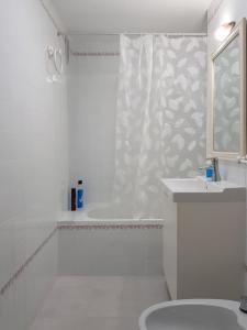 a white bathroom with a shower and a sink at Valdelagrana Mar Ha Apartment in El Puerto de Santa María