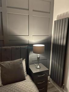 - une chambre avec un lit et une lampe sur une table de chevet dans l'établissement DULEX ROOMS, à Scunthorpe