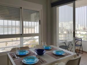 聖瑪麗亞港的住宿－Valdelagrana Mar Ha Apartment，一间带桌椅和窗户的用餐室