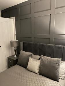 um quarto com uma cama com uma cabeceira cinzenta em DULEX ROOMS em Scunthorpe