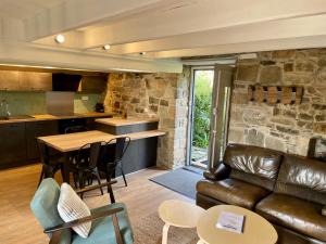 a living room with a leather couch and a table at La Cidrerie du port in Landévennec