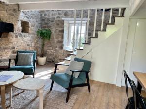 a living room with chairs and a table and stairs at La Cidrerie du port in Landévennec