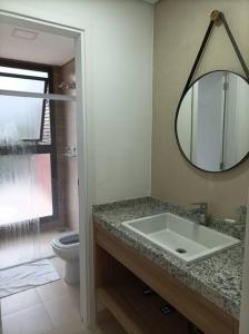 y baño con lavabo, aseo y espejo. en Apartamento no Capivai Eco Resort Residence en Represa Capivari