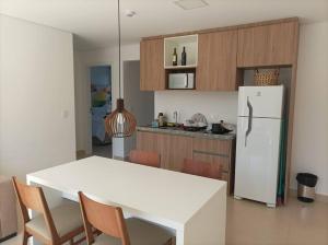 cocina con mesa blanca y nevera blanca en Apartamento no Capivai Eco Resort Residence en Represa Capivari