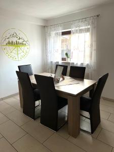 a dining room with a wooden table and black chairs at Ferienwohnung in Oberahr in Oberahr