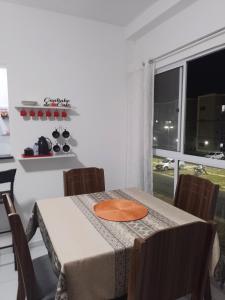 a dining room table with an orange plate on it at Apartamento Inteiro São Luís in São-José-do-Ribamar
