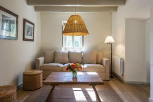 a living room with a couch and a table at Finca Can Romeu alojamiento rural entre viñedos in Font-Rubí