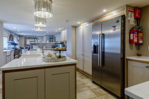 a large kitchen with a stainless steel refrigerator at The Grousemoor - North Wales luxury 7 bedroom holiday rental in Llandegla