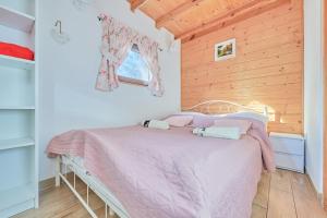 - une chambre avec un lit et une couverture rose dans l'établissement Agroturystyka Barycz Całoroczny Domek Marcel, à Końskie