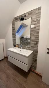 uma casa de banho com um lavatório branco e um espelho. em Vila K29 em Bovec