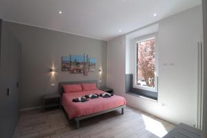 ein Schlafzimmer mit einem rosa Bett und einem Fenster in der Unterkunft Sun Bologna in Bologna