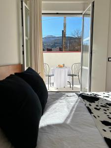 a bed in a room with a table and a view at Bicis & Vacas in La Pola de Gordón