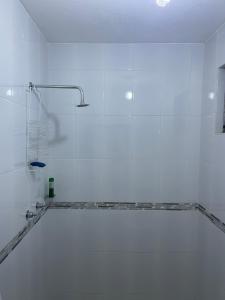 a white bathroom with a tub with a shower at Departamentos huerta in Taxco de Alarcón