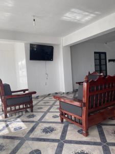 um quarto com duas cadeiras e uma televisão na parede em Departamentos huerta em Taxco de Alarcón
