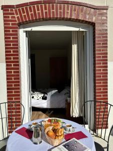 a table with a basket of bread and a bedroom at Bicis & Vacas in La Pola de Gordón