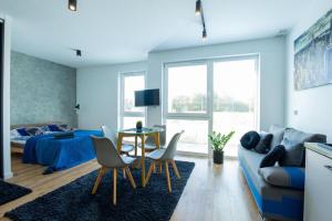 a living room with a couch and a table and chairs at Lux Apartment in Rzeszów